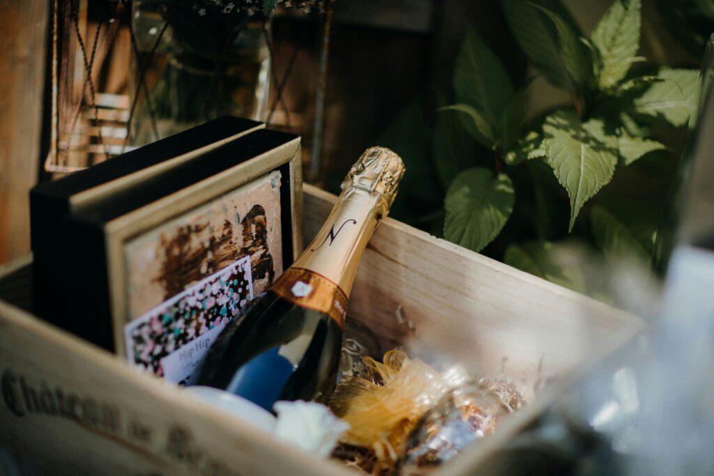 Bottle of champagne nestled in a gift box with elegant packaging.