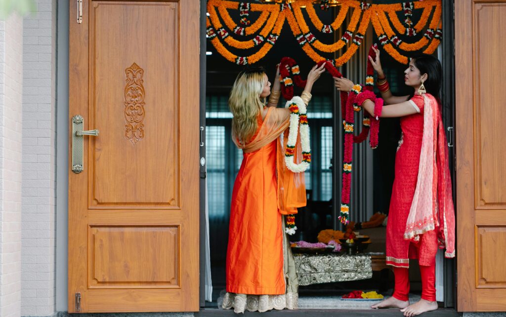 Traditional Indian home entrance decorated for guests with flowers and rangoli.