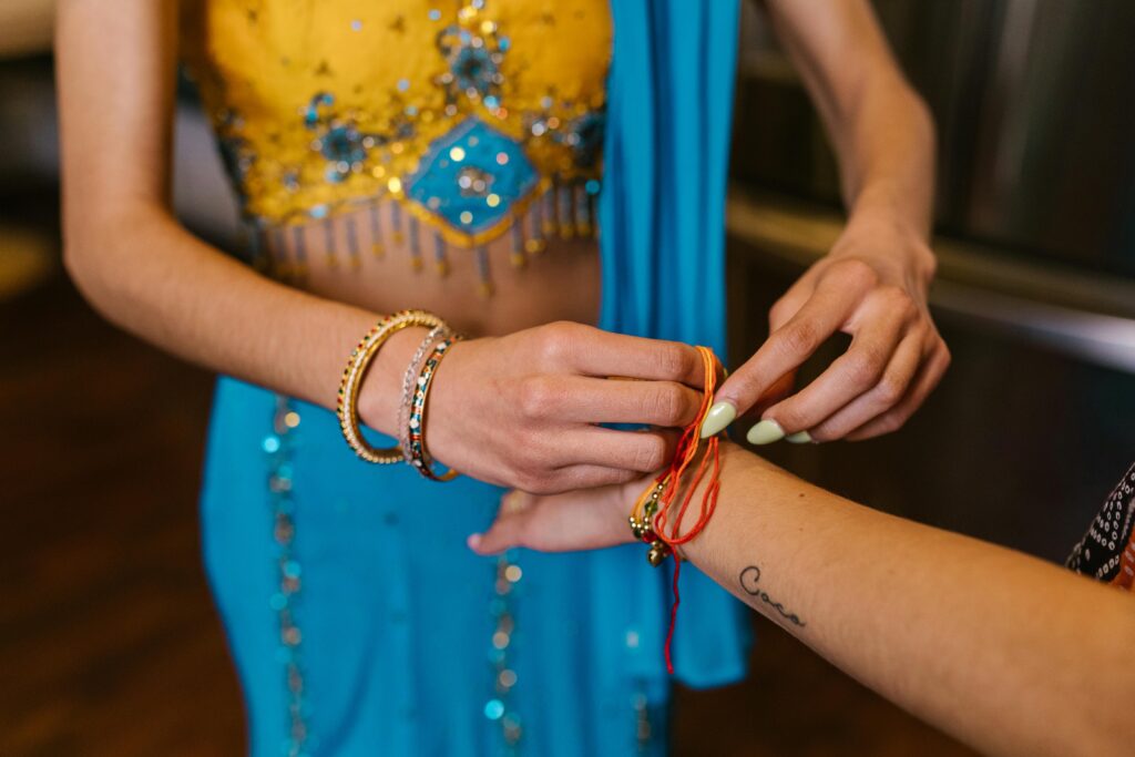 Woman putting on a rakhi bracelet, symbolizing the Raksha Bandhan tradition.